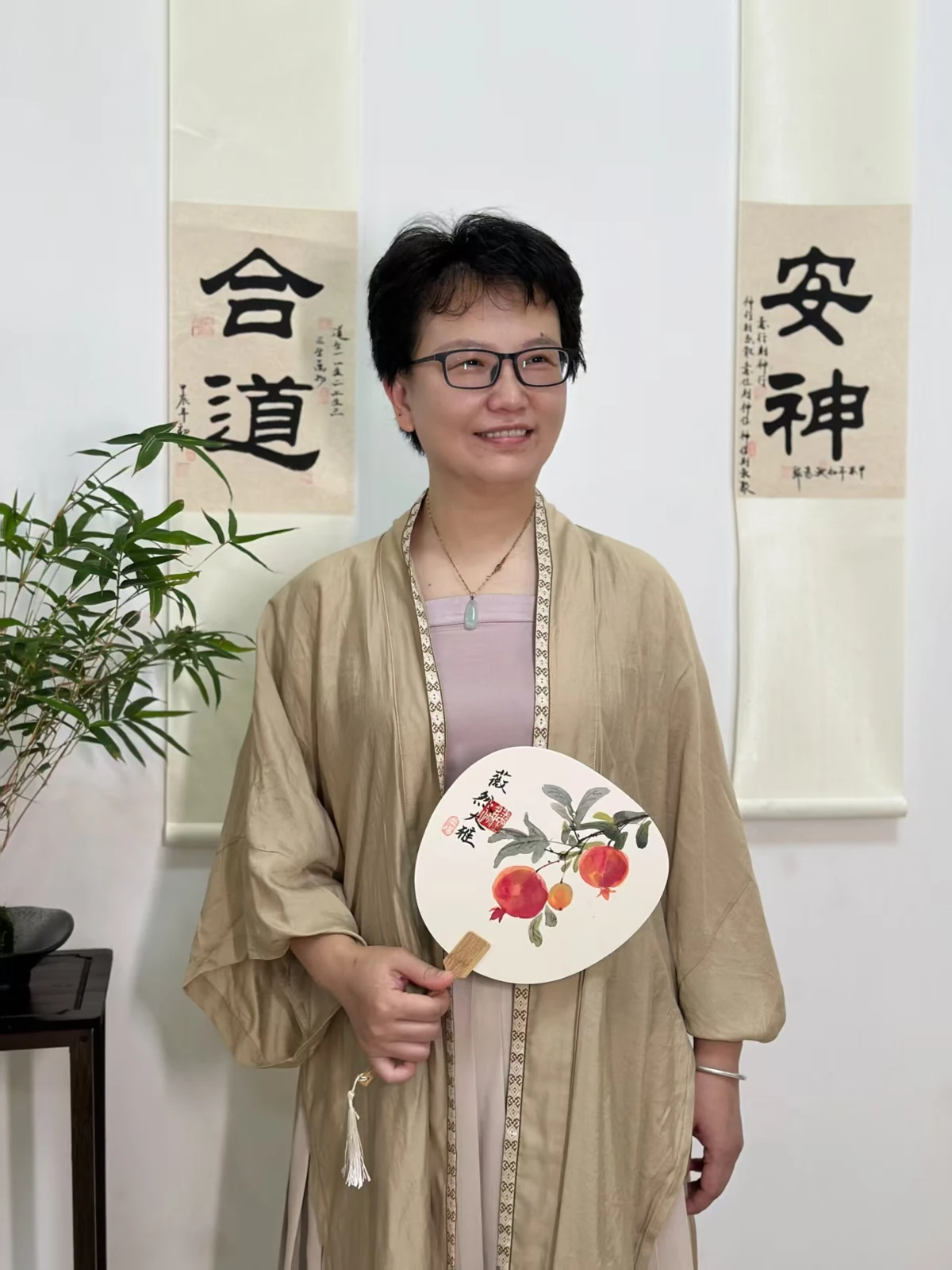 Vicky smiling and holding a painted fan.