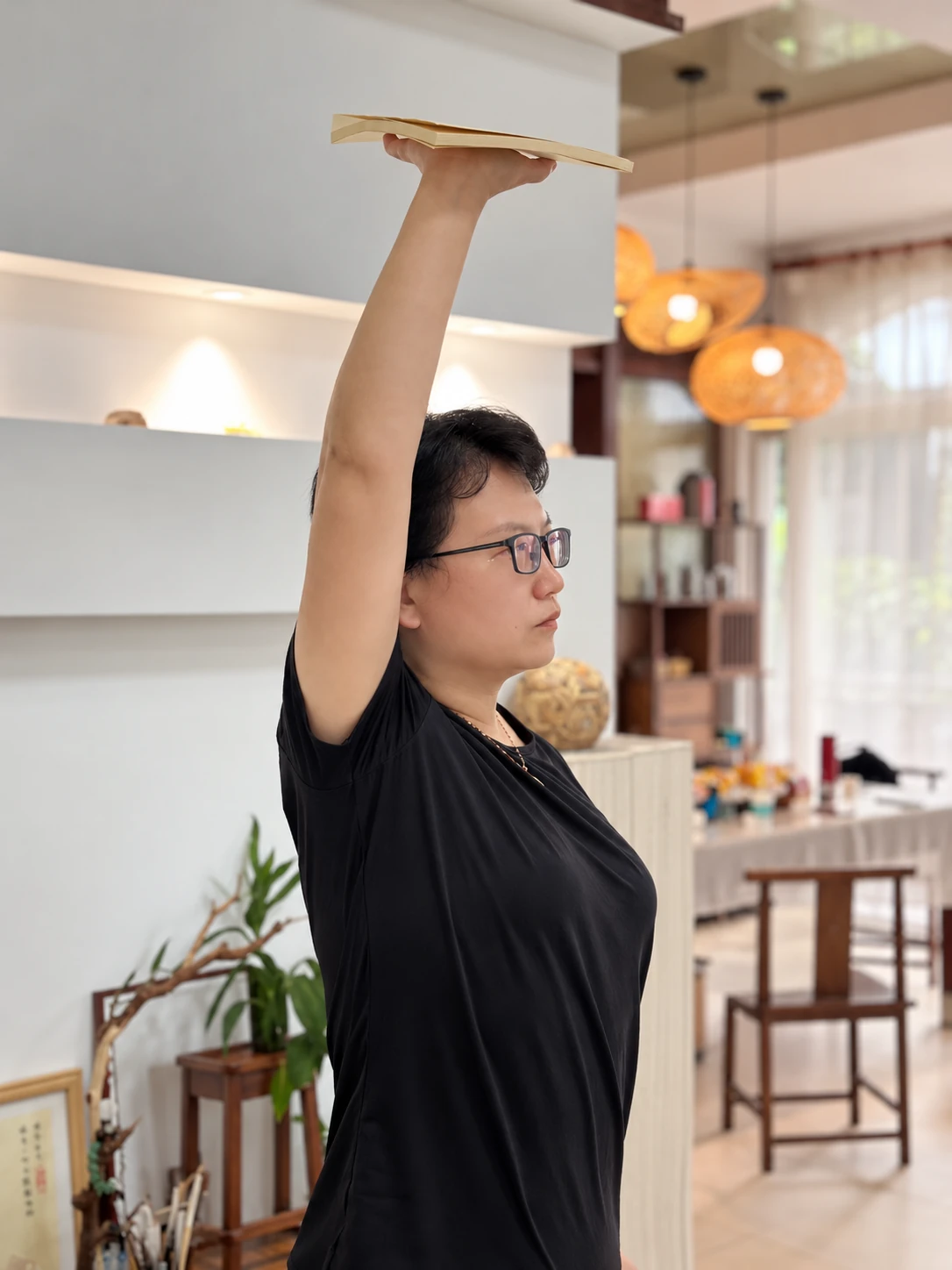 Vicky practising a movement with one arm raised.